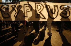 Anti-Troika protesters hold a "Hands off Cyprus" banner during a demonstration outside the EU offices in Nicosia